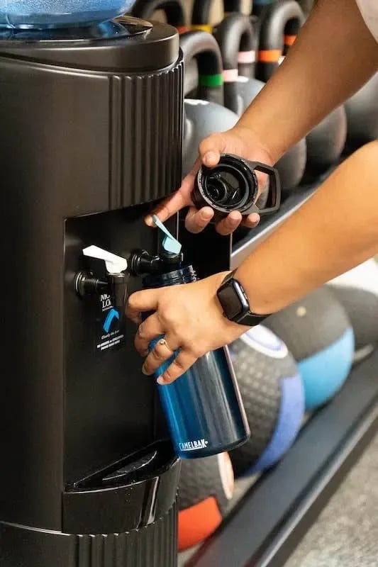 Filling water bottle at gym dispenser playing area at The Switch Adelaide in Adelaide Student Accommodation