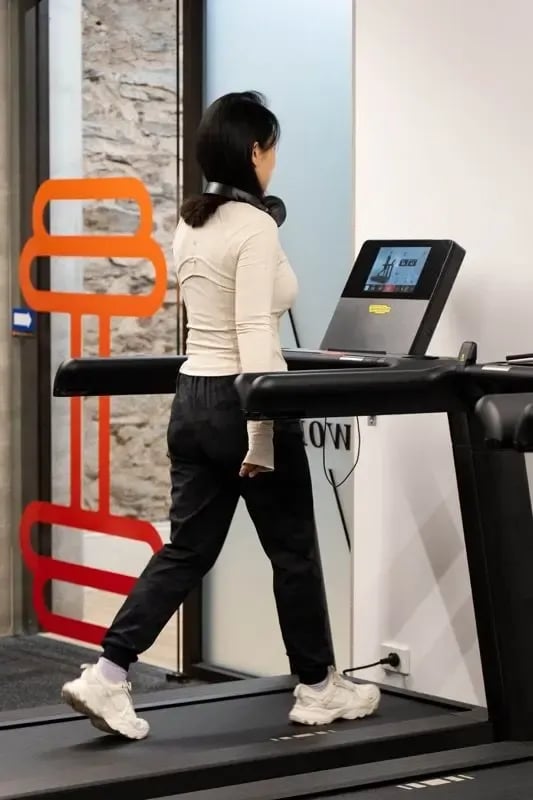Woman running on treadmill with headphones playing area at The Switch Adelaide in Adelaide Student Accommodation