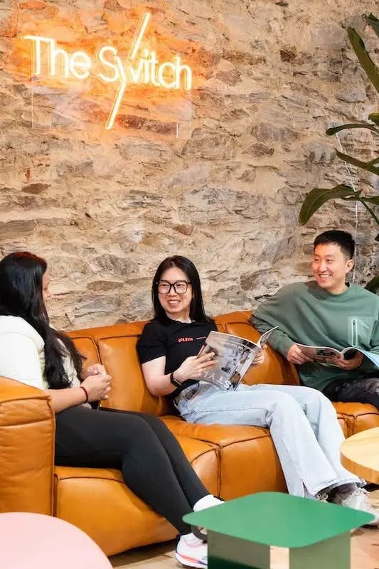 People on couch neon sign living room at The Switch Adelaide in Adelaide Student Accommodation