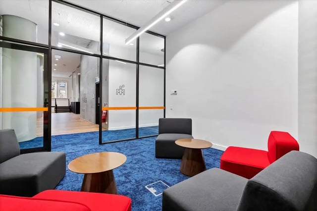 Modern lounge area with chairs tables and blue carpet lounge area at The Switch Adelaide in Adelaide Student Accommodation