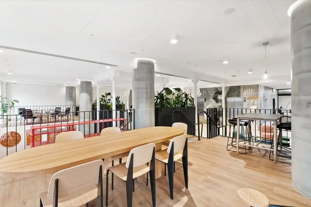 Oval table chairs bar stools and plants communal area at The Switch Adelaide in Adelaide Student Accommodation