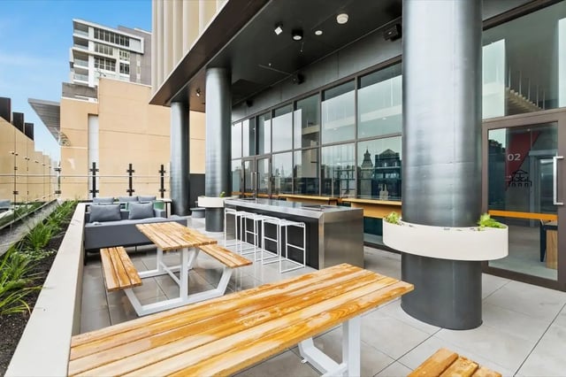 Picnic tables lounge seating bar with stools outdoor area at The Switch Adelaide in Adelaide Student Accommodation
