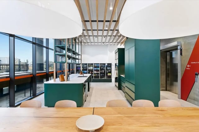 Green island kitchen cabinets with shelves and dining table kitchen at The Switch Adelaide in Adelaide Student Accommodation