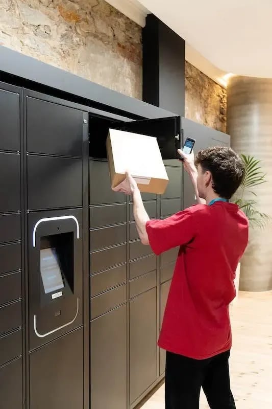 Package locker bank with person placing box Exterior at The Switch Adelaide in Adelaide Student Accommodation