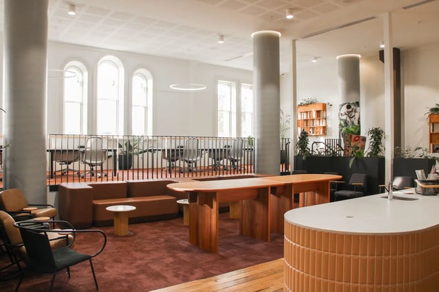 Modern lounge area with tables chairs and kitchen common area at The Switch Adelaide in Adelaide Student Accommodation
