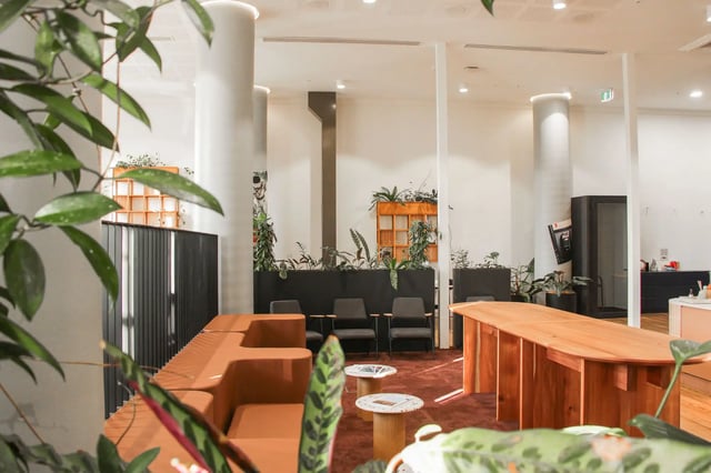Orange sofa, chairs, and wooden table lounge area at The Switch Adelaide in Adelaide Student Accommodation
