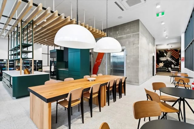 Dining area with kitchen and seating communal living area at The Switch Adelaide in Adelaide Student Accommodation
