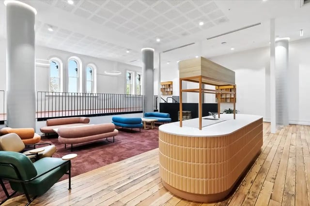 Sofa seating island kitchen counter and wooden floor communal area at The Switch Adelaide in Adelaide Student Accommodation