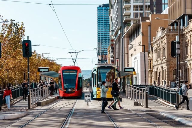 Trams with people crossing street exterior at The Switch Adelaide in Adelaide Student Accommodation