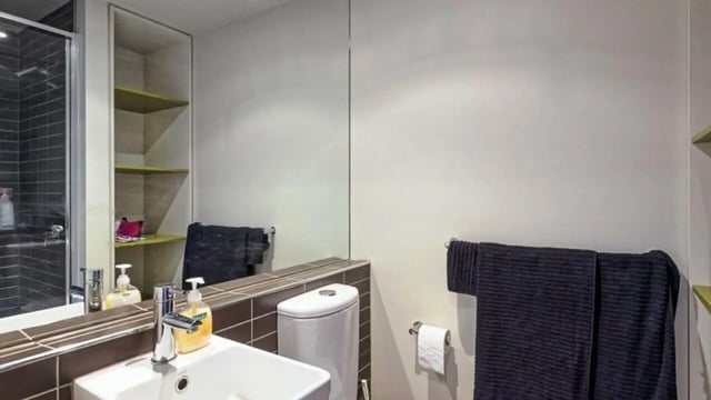 Sink toilet shelves towels shower bathroom at Student Living - Vivida in Melbourne Student Accommodation