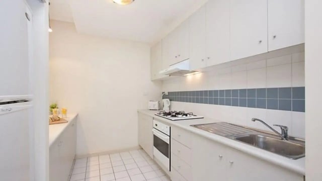 White cabinets fridge stove sink tiled backsplash kitchen at Student Living On ABeckett in Melbourne Student Accommodation