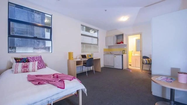 Bed desk kitchen and bathroom student studio at Student Living On ABeckett in Melbourne Student Accommodation