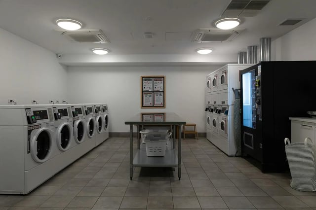 Washing machines dryers table laundry baskets vending machine laundry room at dwell East End Adelaide in Adelaide Student Accommodation