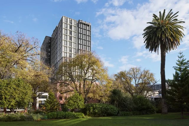 Modern building with trees and palm tree exterior at Campus House in Melbourne Student Accommodation