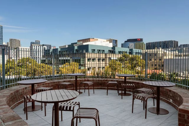 Round tables and stools on terrace exterior at Campus House in Melbourne Student Accommodation