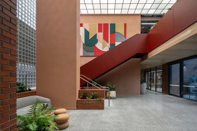 Sofa plants abstract art red staircase lobby at Campus House in Melbourne Student Accommodation