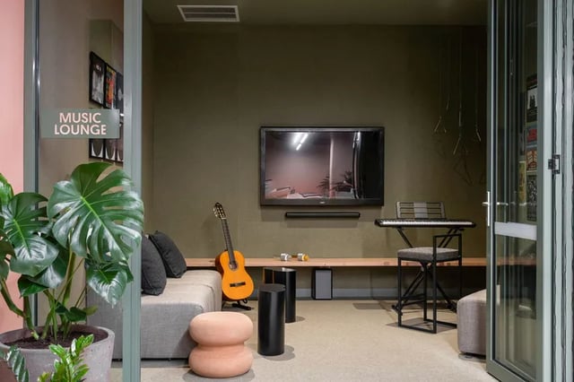 Sofa guitar keyboard TV plant lounge living room at Campus House in Melbourne Student Accommodation