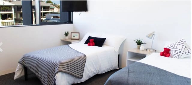 Two beds with red teddy bears and bedside tables bedroom at UniLodge @ Metro Adelaide in Adelaide Student Accommodation