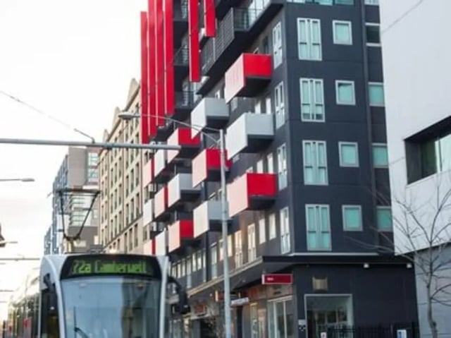Modern building balconies tram passing exterior at Student Living - 740 Swanston in Melbourne Student Accommodation