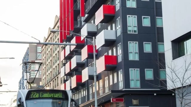 Modern building with red balconies exterior at Student Living - 740 Swanston in Melbourne Student Accommodation