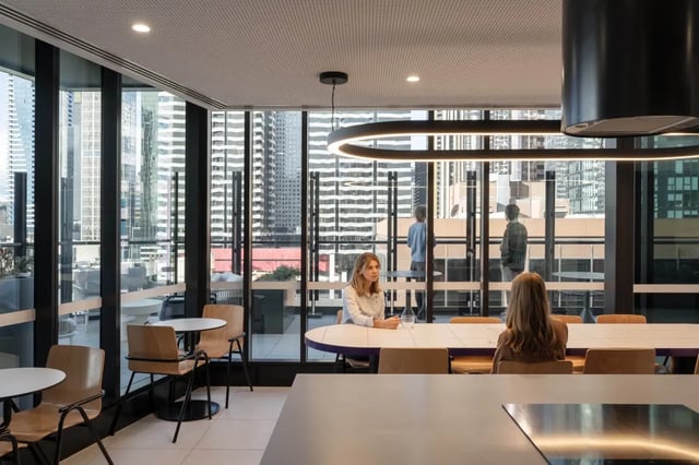 Two women at oval table city view lounge at The Switch Melbourne Victoria Market in Melbourne Student Accommodation