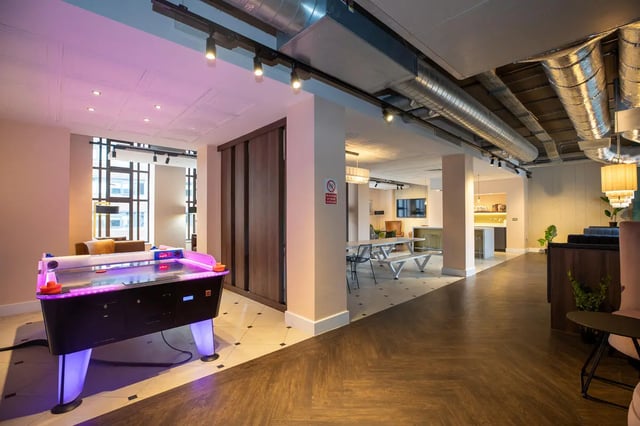 Air hockey table picnic tables and kitchen common area at Collegiate Nova in Nottingham Student Accommodation