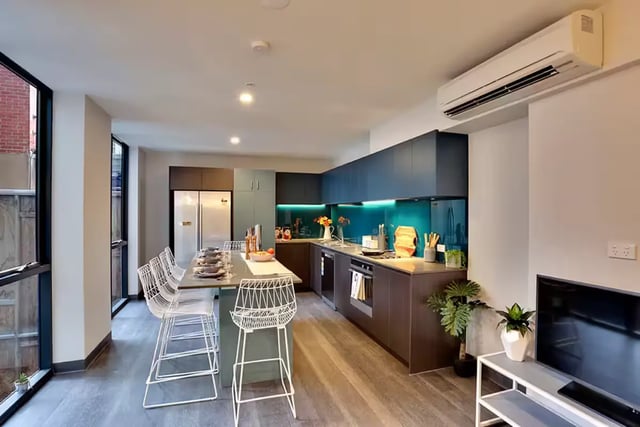 Dining table white chairs modern kitchen living area kitchen at Scape Adelaide University in Adelaide Student Accommodation