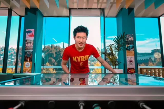 Young man red shirt foosball table common area at Scape Adelaide University in Adelaide Student Accommodation