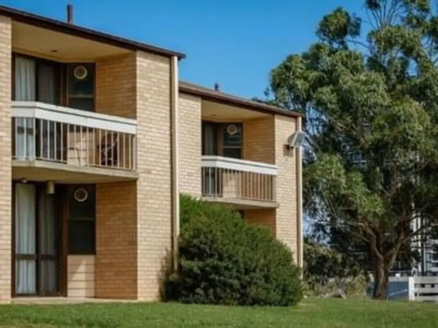 Brick building with balconies and green trees exterior at UniLodge @ UC - Campus West & Guginya in Canberra Student Accommodation