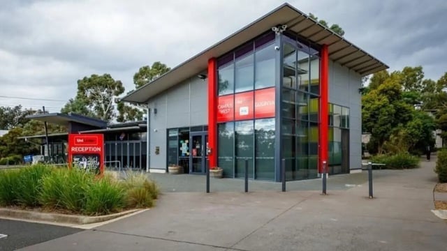 Modern building reception with red signage exterior at UniLodge @ UC - Campus West & Guginya in Canberra Student Accommodation