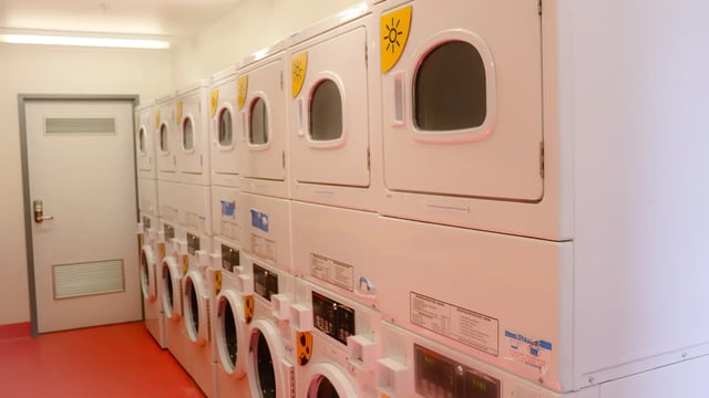 Stack of white washers and dryers laundry room at La Trobe University - Hillside Apartments in Melbourne Student Accommodation