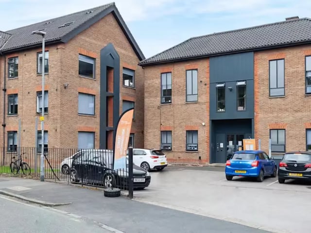 Brick building with cars parked outside exterior at Allen Court in Manchester Student Accommodation