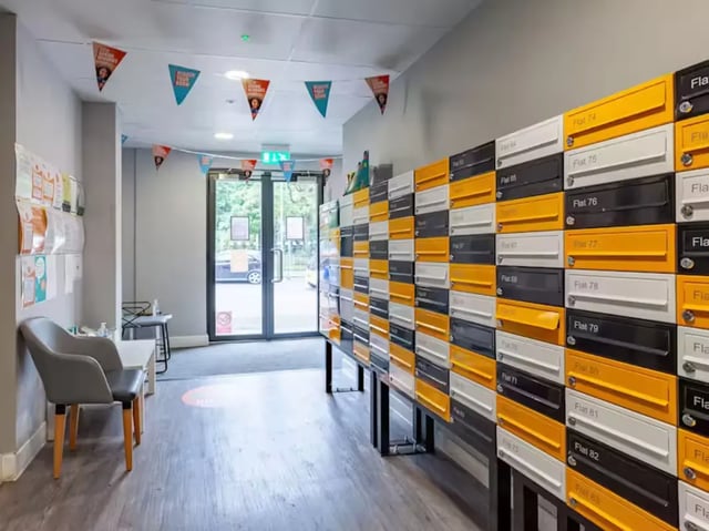 Mailboxes and chair in building corridor exterior at Allen Court in Manchester Student Accommodation