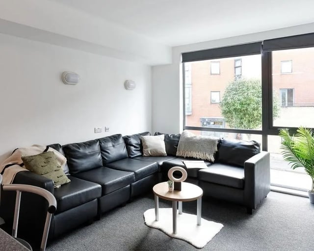 Black sectional sofa with cushions living room at Cavendish Place in Manchester Student Accommodation