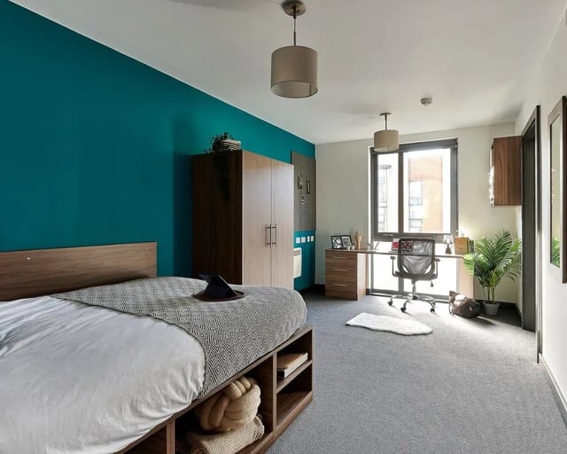 Bed wardrobe desk chair and plant bedroom at Cavendish Place in Manchester Student Accommodation