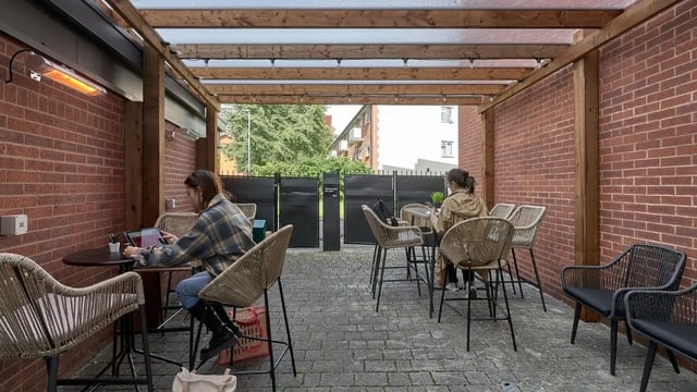 Outdoor seating with brick walls and heaters patio area at Cavendish Place in Manchester Student Accommodation