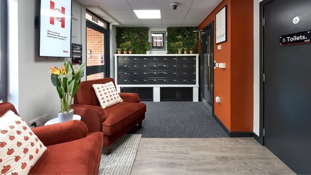 Armchairs plant mailboxes and toilet sign common area at Cavendish Place in Manchester Student Accommodation