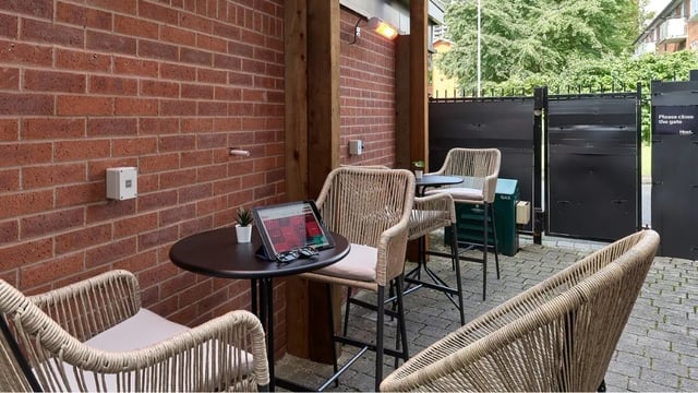 Outdoor seating area with tables chairs and gate exterior at Cavendish Place in Manchester Student Accommodation
