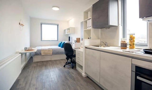 Bed desk chair kitchen and sink studio apartment at Westcombe House in London Student Accommodation