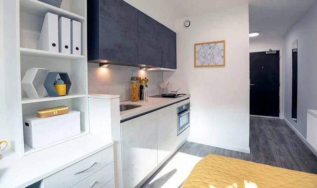 White shelves modern kitchen and hallway exterior at Westcombe House in London Student Accommodation