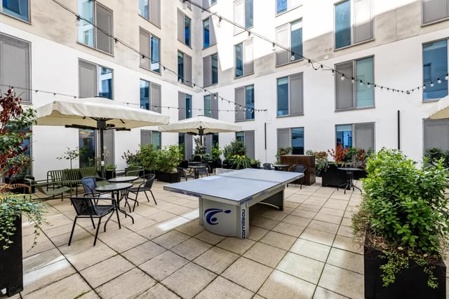 Ping pong table outdoor seating and umbrellas courtyard at Chapter Portobello in London Student Accommodation