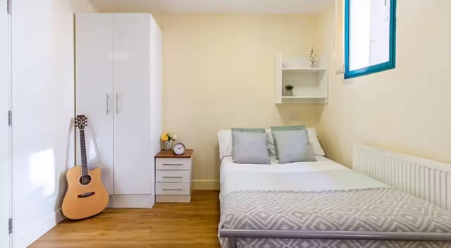 White wardrobe bedside table and bed bedroom at Nottingham Square in Nottingham Student Accommodation
