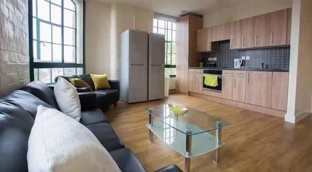 Sofa fridges glass table open plan living kitchen at Nottingham Square in Nottingham Student Accommodation