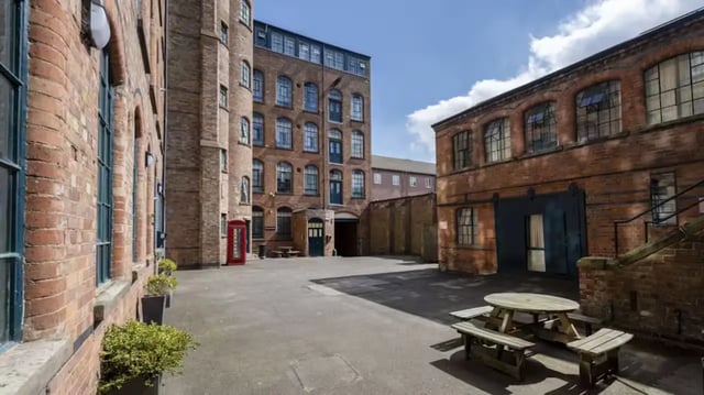 Brick buildings with picnic tables exterior at Nottingham Square in Nottingham Student Accommodation