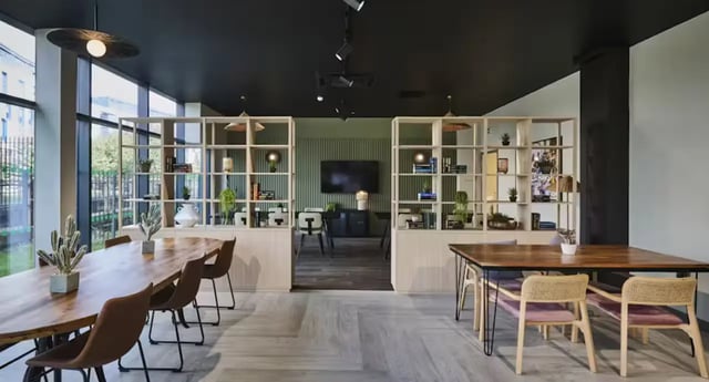 Tables chairs and shelving units communal area at Nottingham Two in Nottingham Student Accommodation