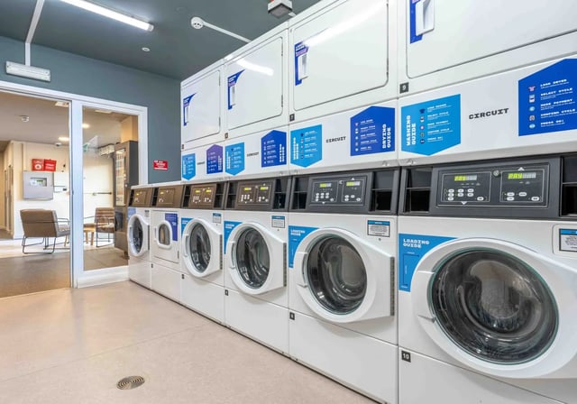 Rows of washing machines and dryers laundry room at iQ The Arcade in London Student Accommodation