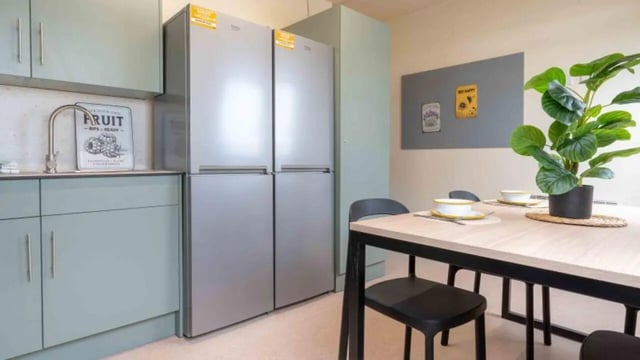 Light blue cabinets fridges and dining table kitchen area at iQ The Arcade in London Student Accommodation
