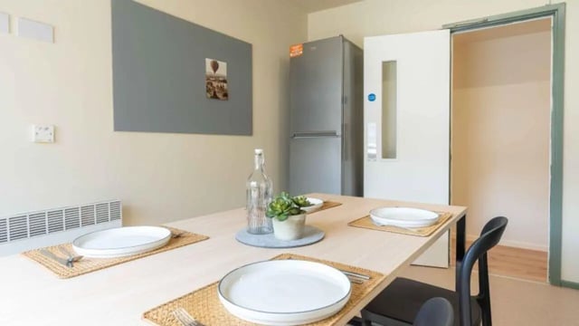 Table with plates and chairs kitchen at iQ The Arcade in London Student Accommodation