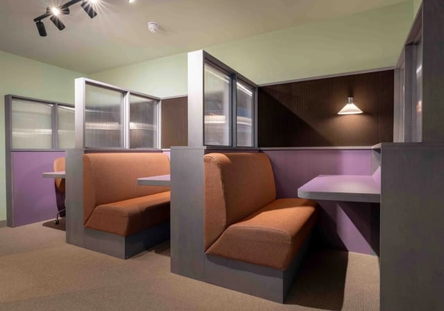 Orange booth seating with desks communal area at iQ Paris Gardens in London Student Accommodation