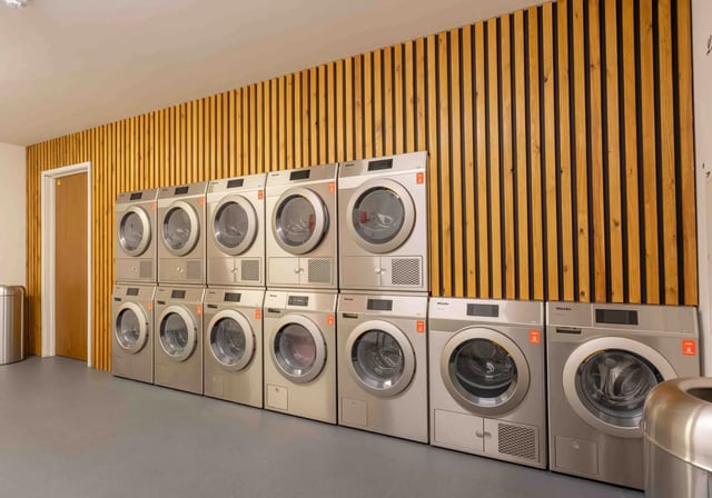 Multiple Miele washers and dryers stacked laundry room at iQ Paris Gardens in London Student Accommodation